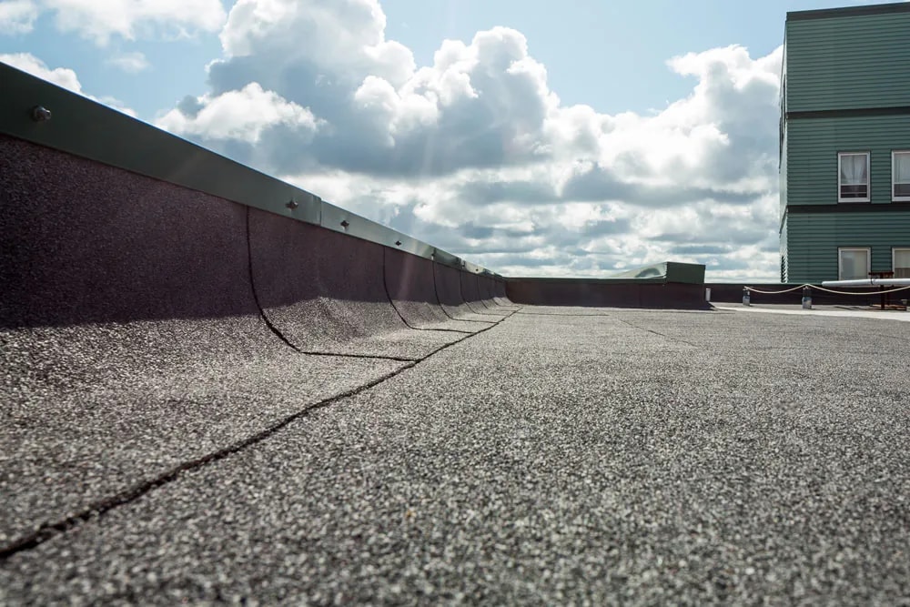 Installed IKO SBS flat roof with granulated membrane and parapet detailing